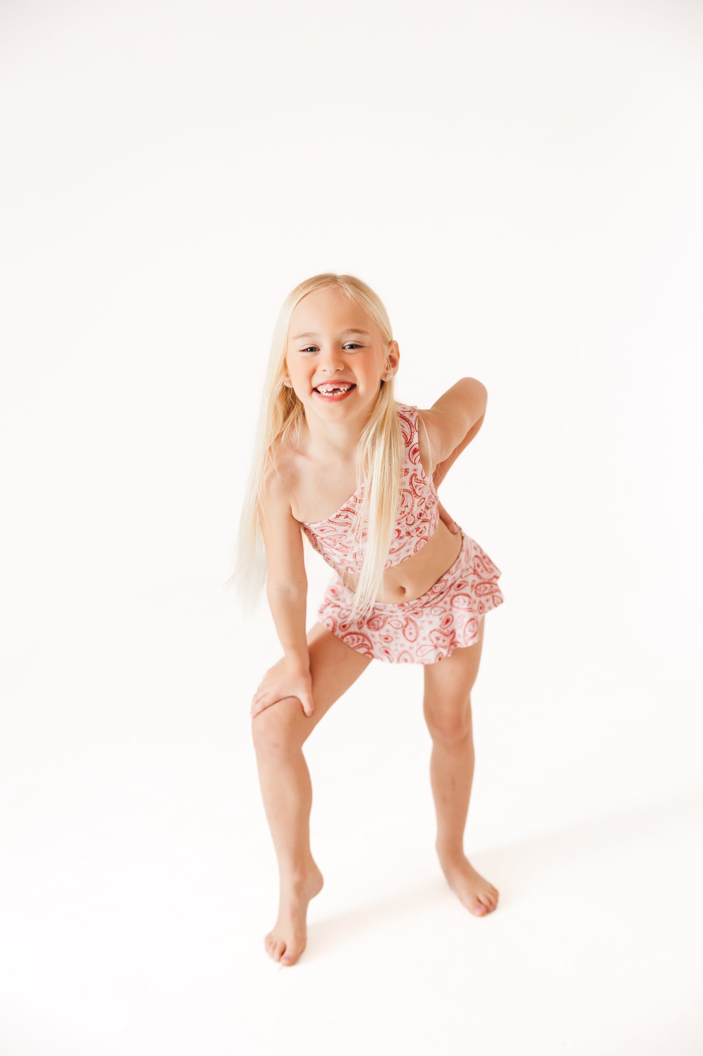 pink, white, and red two piece dance set with one shoulder top and skirt bottoms