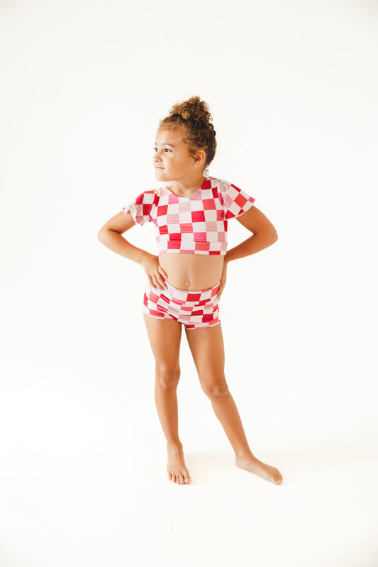 girl wearing pink and white checkered two piece dance outfit
