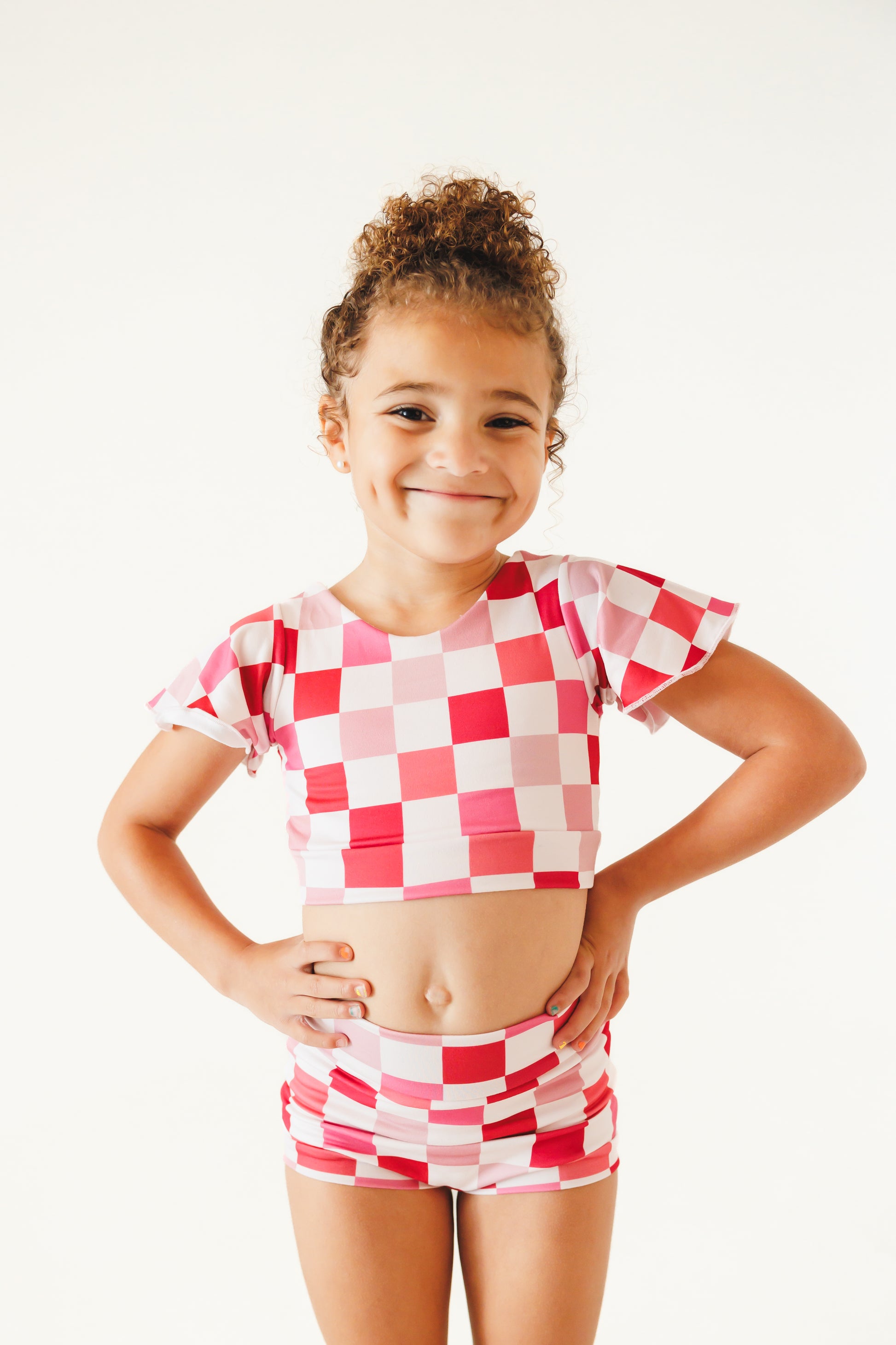 girl wearing pink and white checkered two piece dance outfit