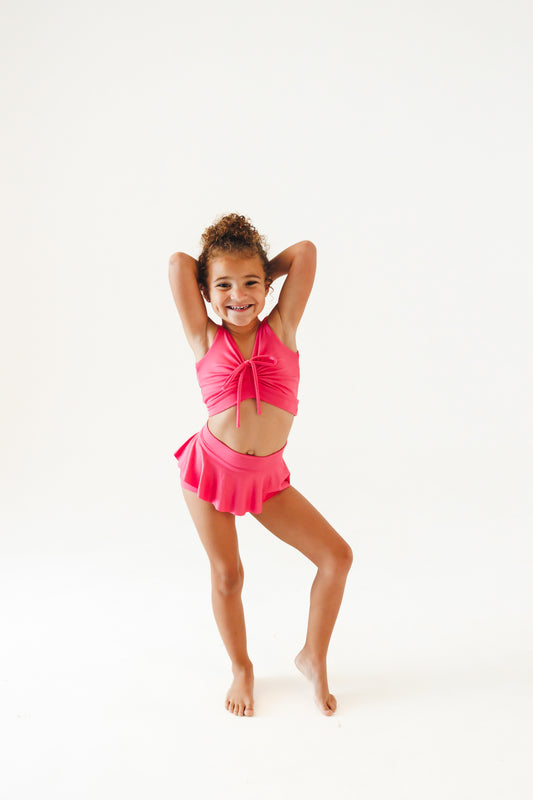 girl wearing hot pink dance set with skirt and cinched top